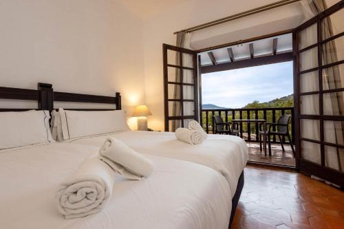 a bedroom with a large bed with a large window at Hotel Tugasa Las Truchas in El Bosque
