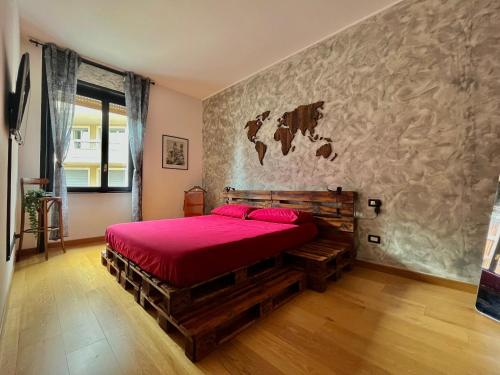 a bedroom with a large bed with a red bedspread at Appartamento Dante in Seregno
