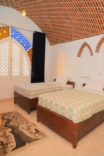 two beds in a room with arched windows at El Hanna Valley View in Luxor