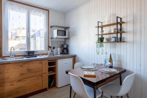 une cuisine avec une table, des chaises et un évier dans l'établissement L'Echappée Bleue - Appt pour 4 Vue mer, à Ault