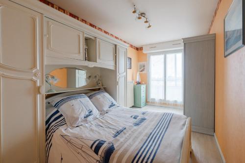 ein Schlafzimmer mit einem Bett und einem großen Fenster in der Unterkunft L'Abri du Cap Horn - Proche plage pour 4 in Courseulles-sur-Mer