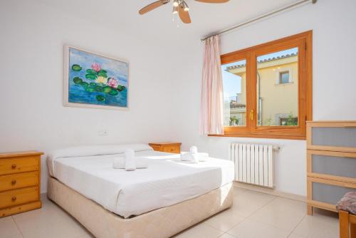 una camera da letto con un grande letto bianco e una finestra di North House a Playa de Muro