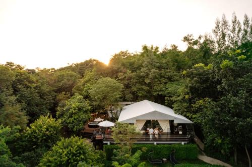 a white tent in the middle of a forest at Te Mata Glamping in Nong Nam Daeng