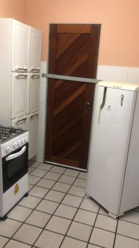 kuchnia z lodówką i drewnianymi drzwiami w obiekcie Dreams w mieście Natal