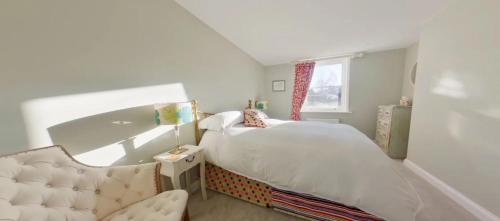1 dormitorio pequeño con 1 cama y 1 silla en North Lodge en Cheltenham