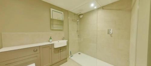 a white bathroom with a sink and a shower at North Lodge in Cheltenham