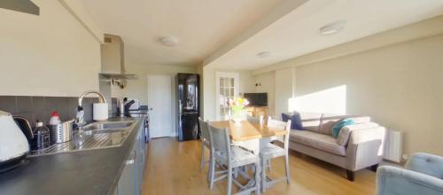 a kitchen and living room with a couch and a table at North Lodge in Cheltenham