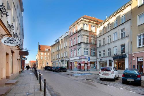 uma rua da cidade com edifícios e carros estacionados na rua em Elite Apartments Garncarska Classy em Gdansk