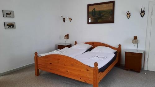 Schlafzimmer mit einem Holzbett mit weißer Bettwäsche in der Unterkunft Gemütliche Ferienwohnung mit Waldblick in Walsrode