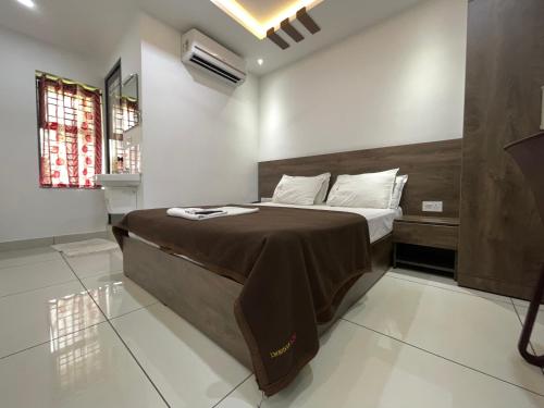 a bedroom with a large bed with a wooden headboard at RK Residency in Kozhikode