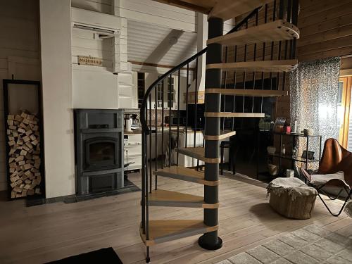 a spiral staircase in a living room with a fireplace at Upea villa lähellä rantaa poreallas & SUP-laudat in Vaasa