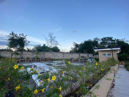 einen Garten mit Tischen und Blumen in der Mitte in der Unterkunft Saekyung Condominium in Lapu Lapu City