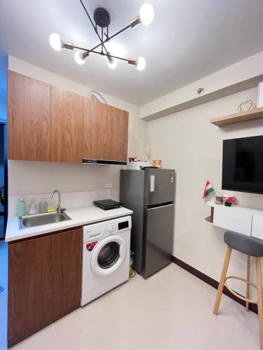 a kitchen with a washing machine and a sink at Saekyung Condominium in Lapu Lapu City