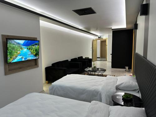 a bedroom with two beds and a tv on a wall at KT SUİTE in Ankara