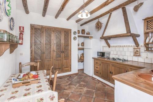 a kitchen with a table and a kitchen with wooden cabinets at Casa Rural Altillo in Zahara de la Sierra
