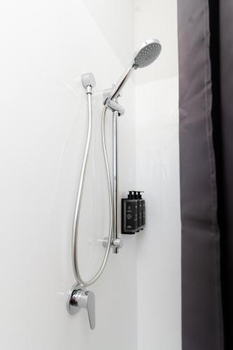 a shower with a shower head on a wall at Haka House Christchurch in Christchurch