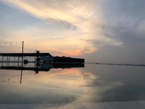 un quai sur une étendue d'eau avec le ciel dans l'établissement the AMARTYA, à Yogyakarta
