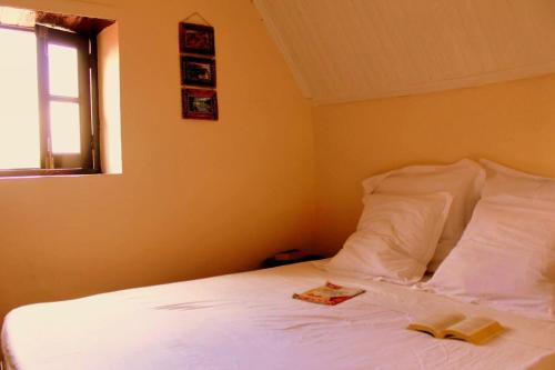 a bedroom with a white bed with two books on it at One bedroom house with wifi at Antananarivo in Antananarivo