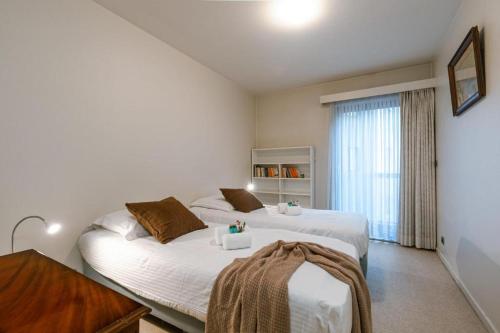een slaapkamer met 2 bedden en een raam bij Apartment Alios in Oostende