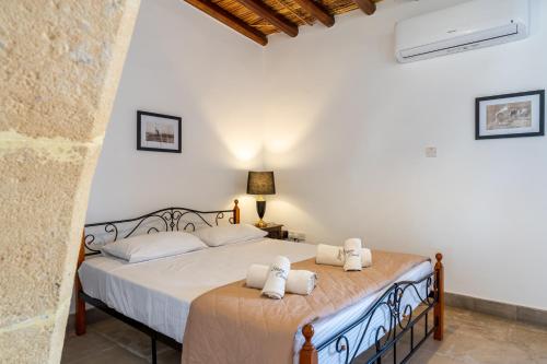 a bedroom with a bed with white sheets and pillows at Stone Court Boutique Studios in Paphos City