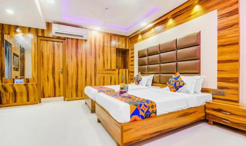 a bedroom with a large bed and wooden walls at FabHotel Prime Orion Crystal in Kolkata