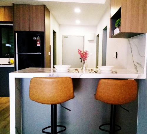 a kitchen with two chairs at a kitchen counter at Executive Escapes [The Netizen Cheras] 3房公寓 #MRT in Cheras