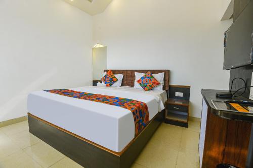 1 dormitorio con 1 cama blanca grande y TV en FabHotel Prime WS Beach Resort, en Goa