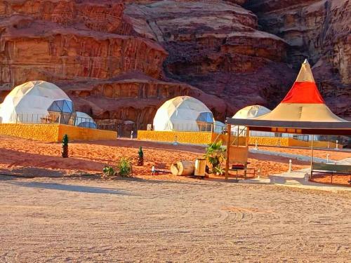 a group of domes in a desert with a mountain at Bubble RumCamp in Wadi Rum