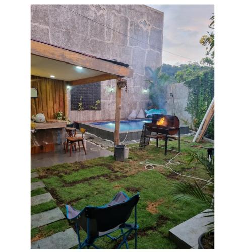 einen Hinterhof mit einem Pool, einem Tisch und Stühlen in der Unterkunft Cathy's place in Kampungdurian