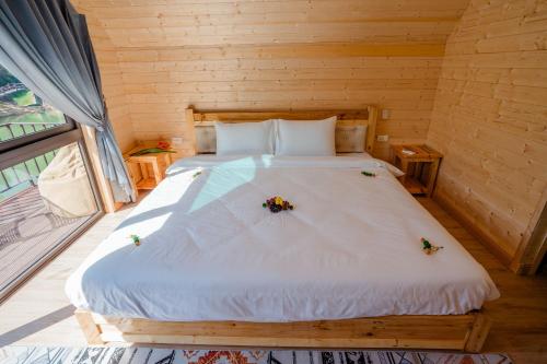 a bedroom with a bed with flowers on it at Bai Tu Long Mountain Resort in Hà Cái