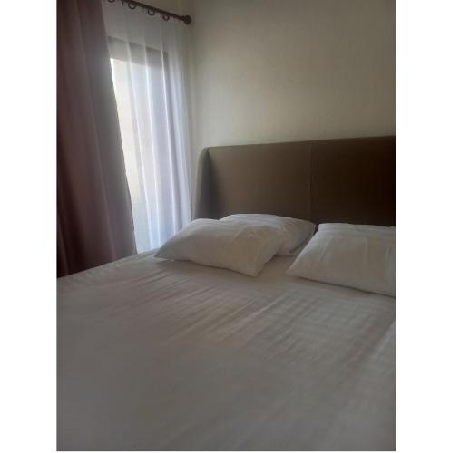 - un lit avec 2 oreillers et une fenêtre dans l'établissement Cathy's place, à Kampungdurian