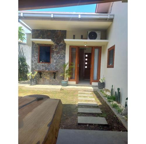 ein Haus mit einer Eingangstür und einer Steinmauer in der Unterkunft Cathy's place in Kampungdurian