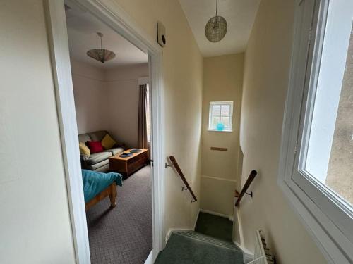 a hallway leading to a living room with a couch at The“LITTLE BOLT”In Reading. in Earley