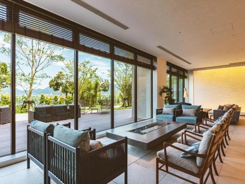 a living room with chairs and a table and windows at Etajimasou in Etajima