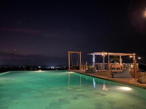 uma piscina à noite com água azul em the AMARTYA em Yogyakarta