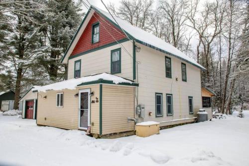 a white house with a red roof in the snow at 4 BDRM - Hot Tub - Fire Pit in Old Forge