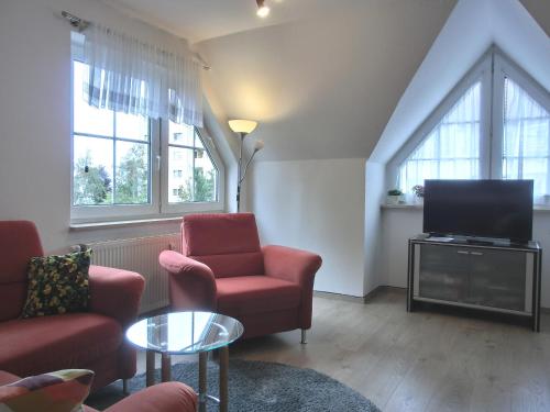 a living room with two chairs and a flat screen tv at Ferienwohnung P3 in Graal-Müritz