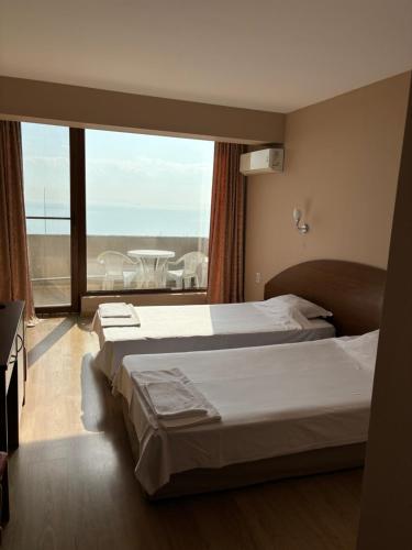 a bedroom with two beds and a large window at Relax Sarafovo in Burgas City