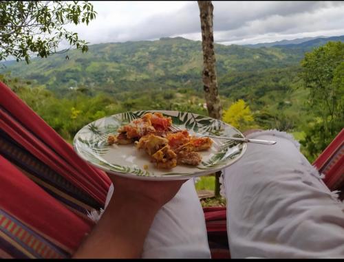 una persona sosteniendo un plato de comida con vistas en Cabaña Aguadulce, en San Rafael