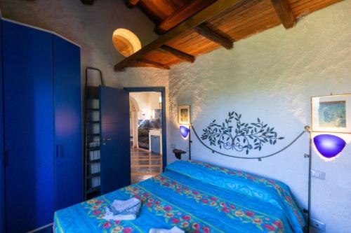 1 dormitorio con 1 cama azul en una habitación en Villa Teresa Country Lodges, en San Nicolò