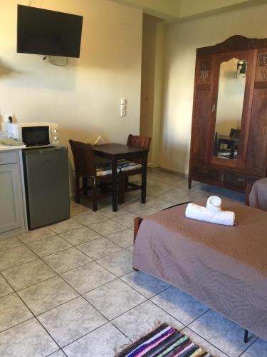 a room with a bed and a kitchen with a table at happyWish Syros in Ermoupoli
