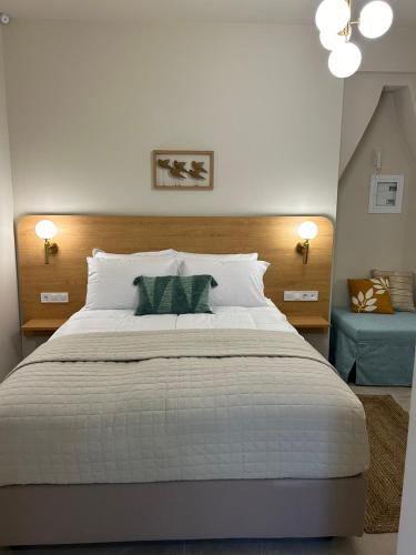 a bedroom with a large white bed and a blue couch at Living Yard Acropolis in Athens