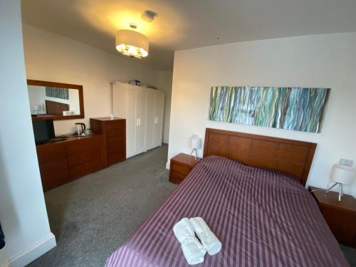 ein Schlafzimmer mit einem Bett mit zwei Handtüchern darauf in der Unterkunft Kingfisher En-suite Room in Plymouth