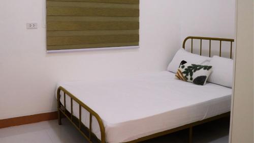 uma cama com lençóis brancos e almofadas num quarto em Caza Lozada em Salaban
