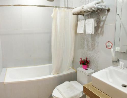 La salle de bains est pourvue de toilettes, d'un lavabo et d'une baignoire. dans l'établissement AMORE HOTEL MANILA, à Manille