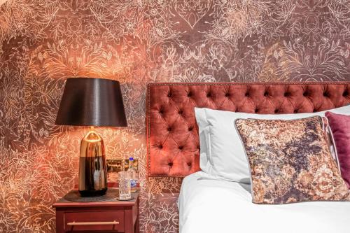 a bedroom with a bed and a lamp on a nightstand at The Ley Arms in Exeter