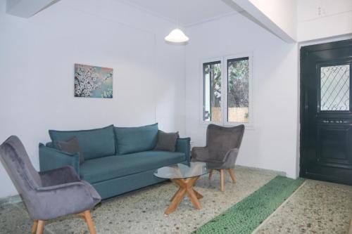 a living room with a blue couch and two chairs at Magical villa western peloponnese by MPS in Pýrgos