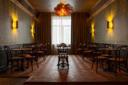 een eetkamer met tafels en stoelen en een kroonluchter bij Gibsons Hotell in Jonsered