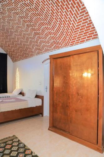 a bedroom with a bed and a wooden cabinet at El Hanna Valley View in Luxor