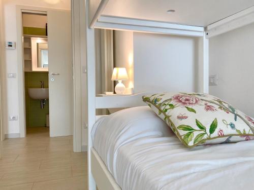 ein Schlafzimmer mit einem weißen Bett und einem Kissen darauf in der Unterkunft Il Castelluccio in San Vincenzo